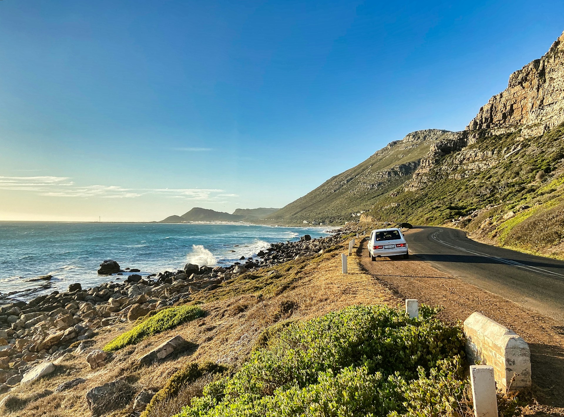 white-car-on-road-near-body-of-water-during-daytime